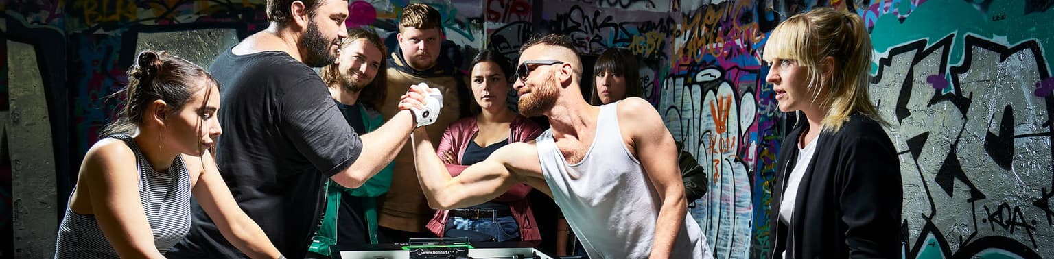 Mehrere Leute stehen um einen Kickertisch von Leonhart