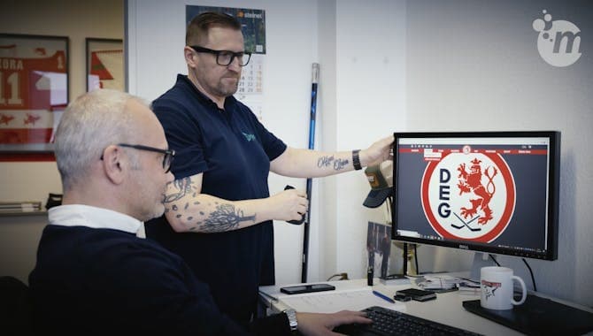 Zwei Männer sitzen vor einem Monitor und besprechen entwas